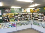 Budtenders at Sticky’s Pot Shop wait for customers to arrive for a closing sale in July following a court decision that led to the store’s closing.