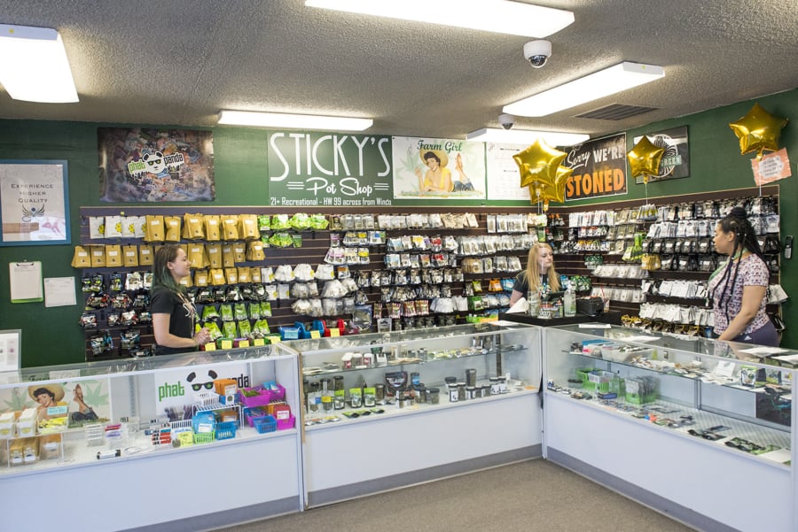Budtenders at Sticky’s Pot Shop wait for customers to arrive for a closing sale in July following a court decision that led to the store’s closing.