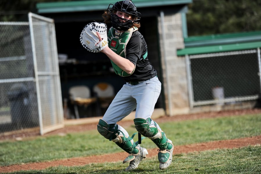Evergreen senior catcher Blake Whitehead, the glue guy on a small roster, winds up to throw a ball to coach Chad Burchett at Evergreen High School.