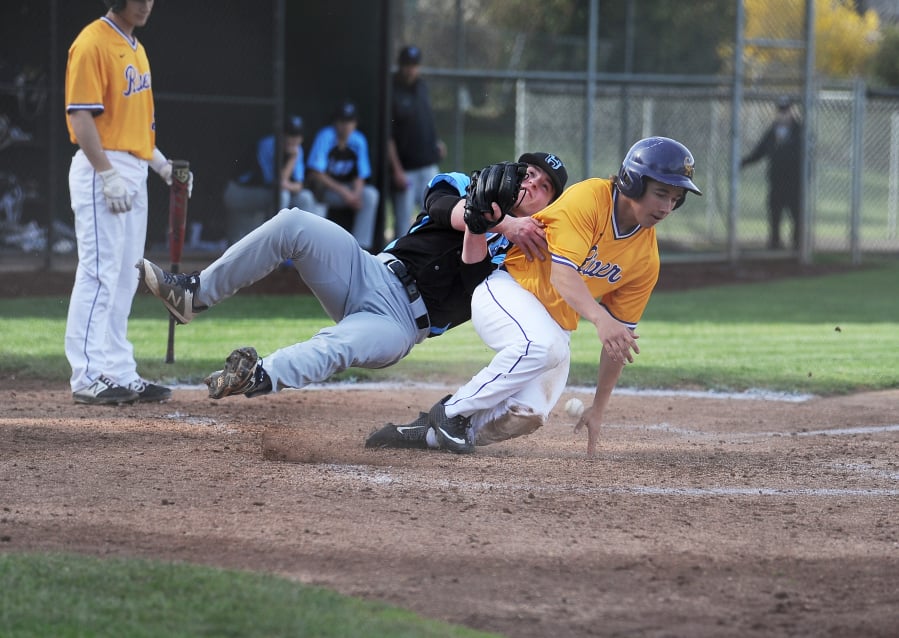 Columbia River’s Kaleb Kier scores on a wild pitch as Hockinson pitcher Cody Wheeler covers home plate in the second inning of River’s 12-5 win on Friday.