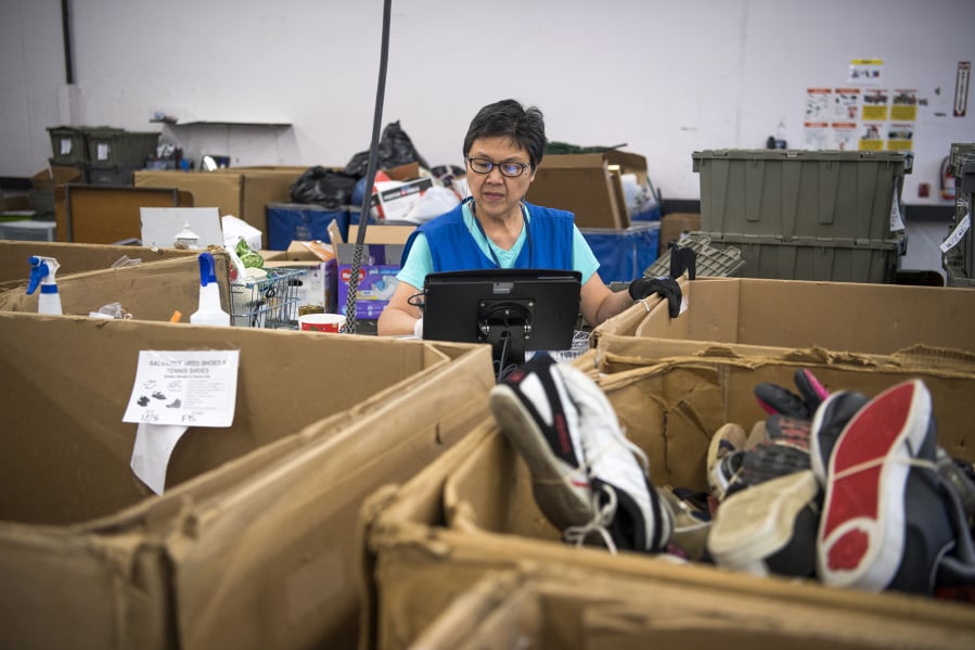 Lucia Mercado of Washougal sorts items in the intake area of Goodwill in Vancouver on Feb. 1.