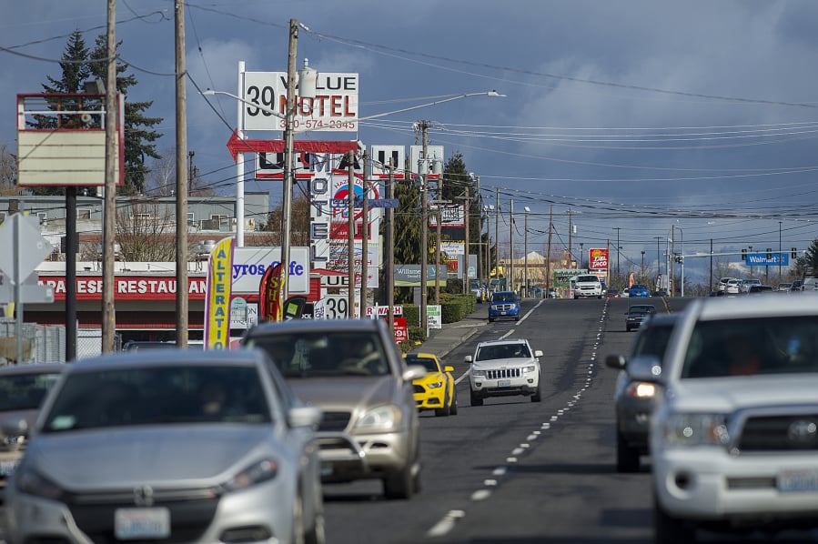 Motorists drive past businesses along a stretch of Highway 99 in Hazel Dell, shown using a telephoto lens that compresses the view. The Highway 99 corridor is considered to be an economic development priority by the Clark County Council, which is part of why the area was selected as one of the county’s seven Opportunity Zones, a new federal designation aimed at encouraging local investment.
