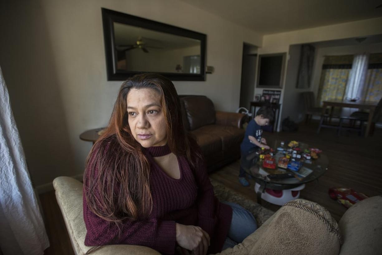 Claudia Franson gazes out of the window of her home in Hazel Dell while her son, Maximus Orellana, plays with a collection of toy cars. Franson is a stay-at-home mom for her nine children but will soon be entering the workforce. Legislators in Olympia are considering a bill intended to help families like hers.