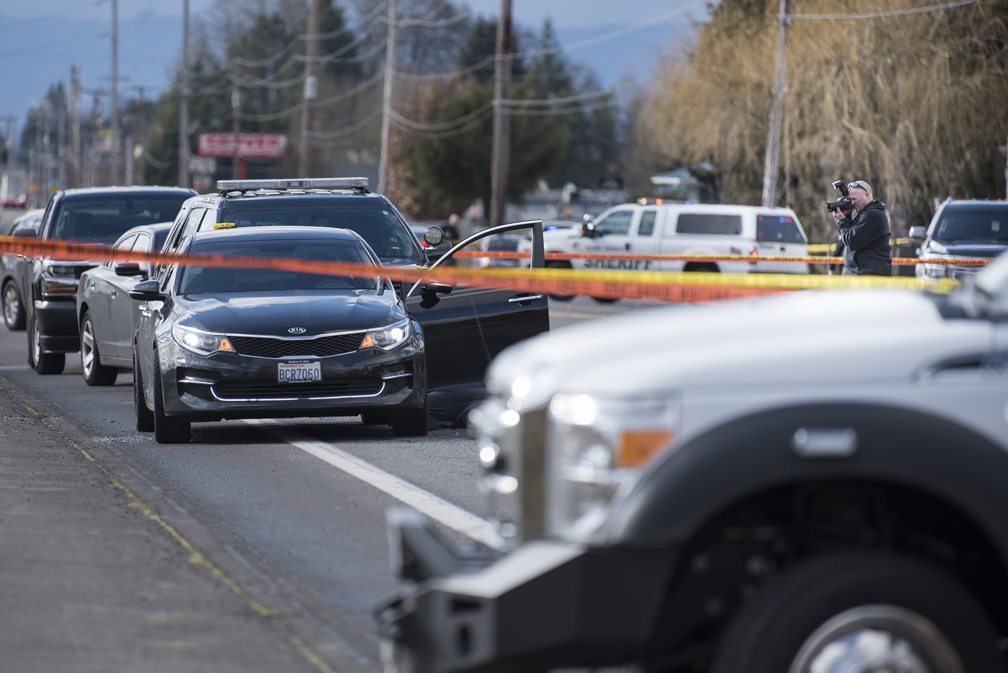 An investigator photographs the scene of a police shooting in Hazel Dell on Thursday, March 7, 2019.