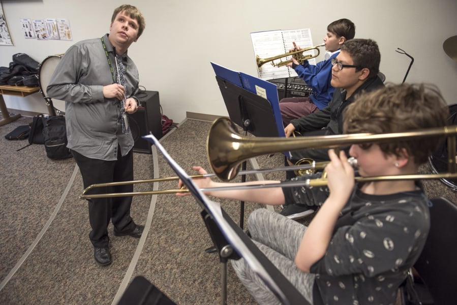 Music teacher Shane Dittmar of the Washington State School for the Blind, left, listens carefully as beginning band students Jaymes Gummere (in back), Xavier Lopez and Olivia McGraw work on scales and rhythms.