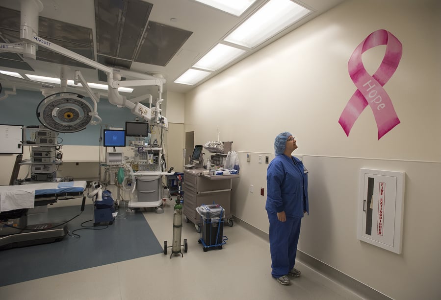 Operating room manager Jen Walling looks at a newly painted pink ribbon in a Legacy Salmon Creek Medical Center operating room. The operating room frequently has breast cancer surgeries in it, and the pink ribbon, which has the word “hope” painted on it, is a positive symbol for breast cancer patients.