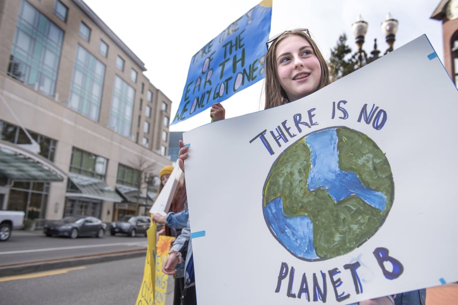Maia Wolverton, 16, participates in a protest of inaction around climate change with other local teenagers near Esther Short Park on Friday afternoon. Teenagers around the world participated in a climate strike, including hundreds in Portland and Seattle. “You have to start somewhere,” Wolverton said.