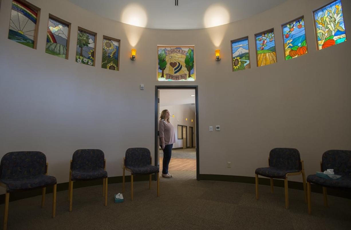 Support services coordinator Erin Orren pauses in the doorway of the Seasons of Hope Room as colorful stained glass windows are seen overhead at Community Home Health & Hospice’s Seasons of Hope Grief Center in Salmon Creek. The stain-glass windows were made by Portland artist David Schlicker.