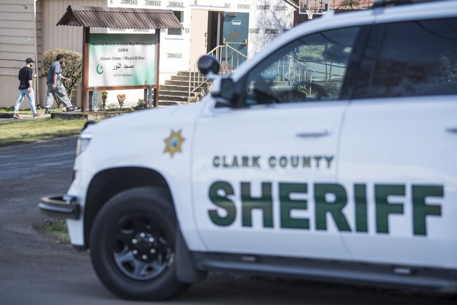 A Clark County sheriff’s deputy sits in his cruiser as worshippers walk into at Masjid Al Noor (Mosque of Light) at the Islamic Society of Southwest Washington in Hazel Dell on Friday.