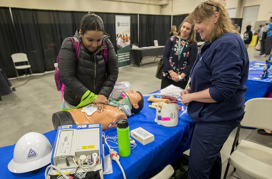 Mountain View High School senior Danayt Tewelde, 18, from left, practices her CPR skills while joined by job coach Ashleigh Byrne and Donna Mairose of PeaceHealth Southwest Medical Center during the Youth Employment Summit on Tuesday. Workforce Southwest Washington gathered representatives from 65 businesses to talk with around 600 young people from Clark and Cowlitz counties during the event.