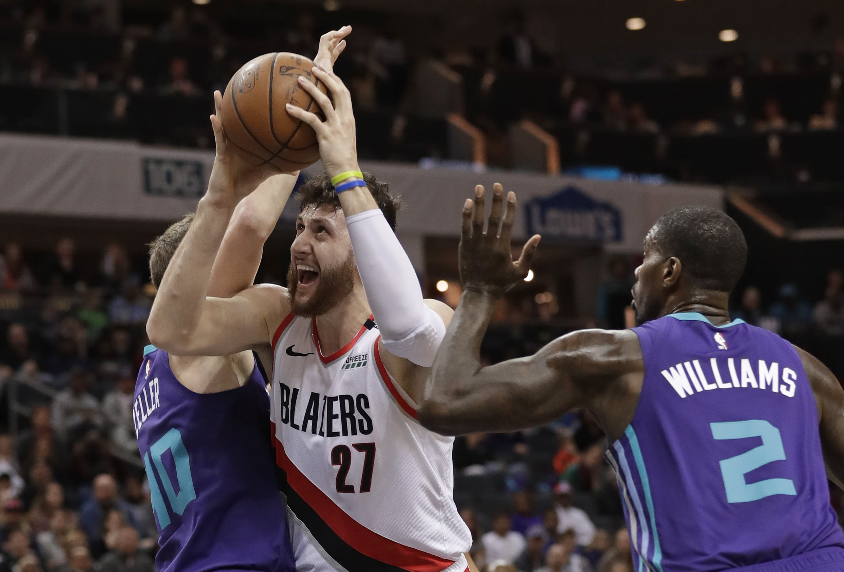 Portland Trail Blazers' Jusuf Nurkic (27) drives between Charlotte Hornets' Marvin Williams (2) and Cody Zeller (40) during the first half of an NBA basketball game in Charlotte, N.C., Sunday, March 3, 2019.