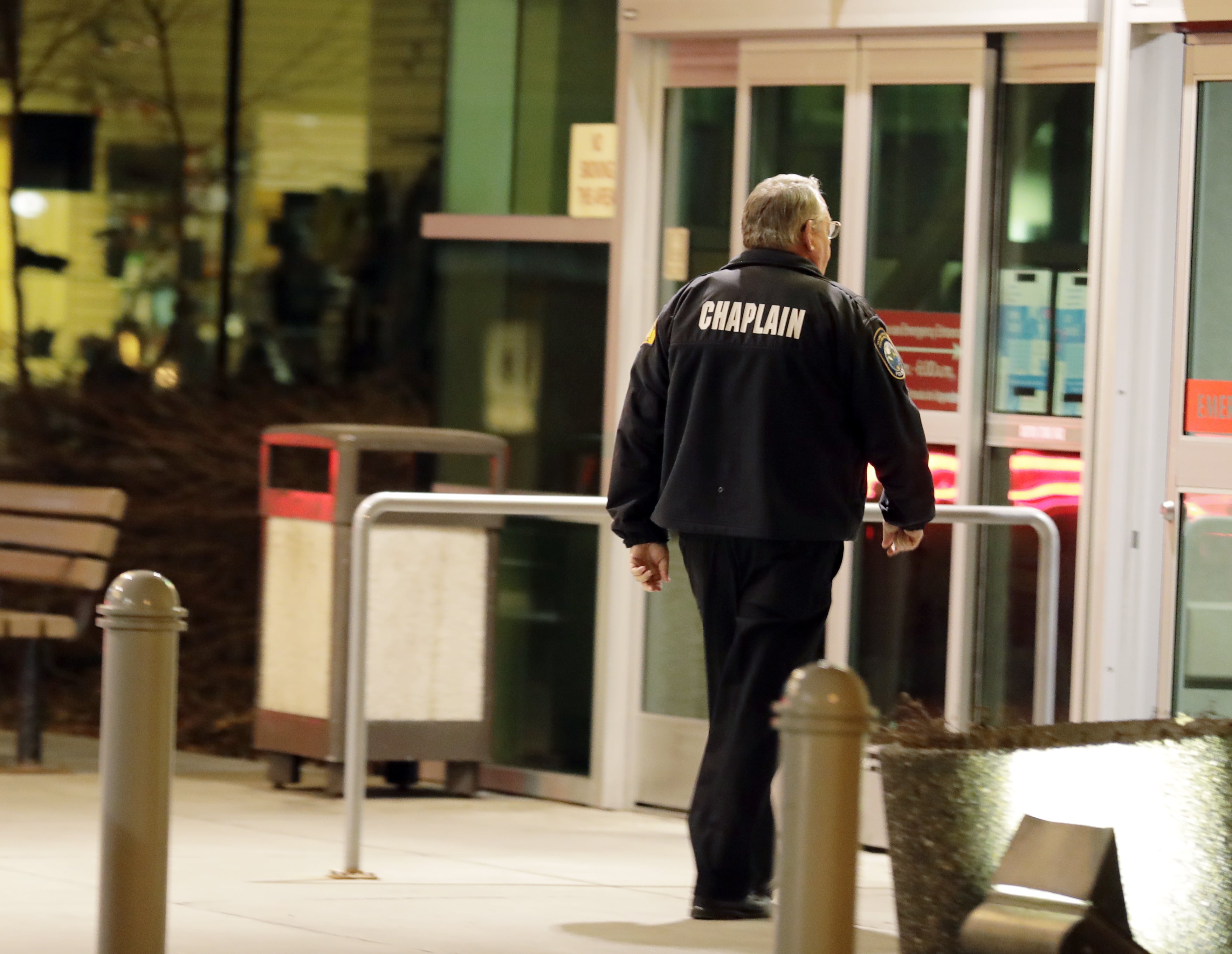 A law enforcement chaplain walks into Kittitas Valley Healthcare Hospital, in the late night hours of Tuesday, March 19, 2019, in Ellensburg, Wash., prior to a procession to accompany the body of a Kittitas County Sheriff's deputy away from the hospital. A Kittitas County Sheriff's deputy was killed and a police officer was injured after an exchange of gunfire during an attempted traffic stop. (AP Photo/Ted S.