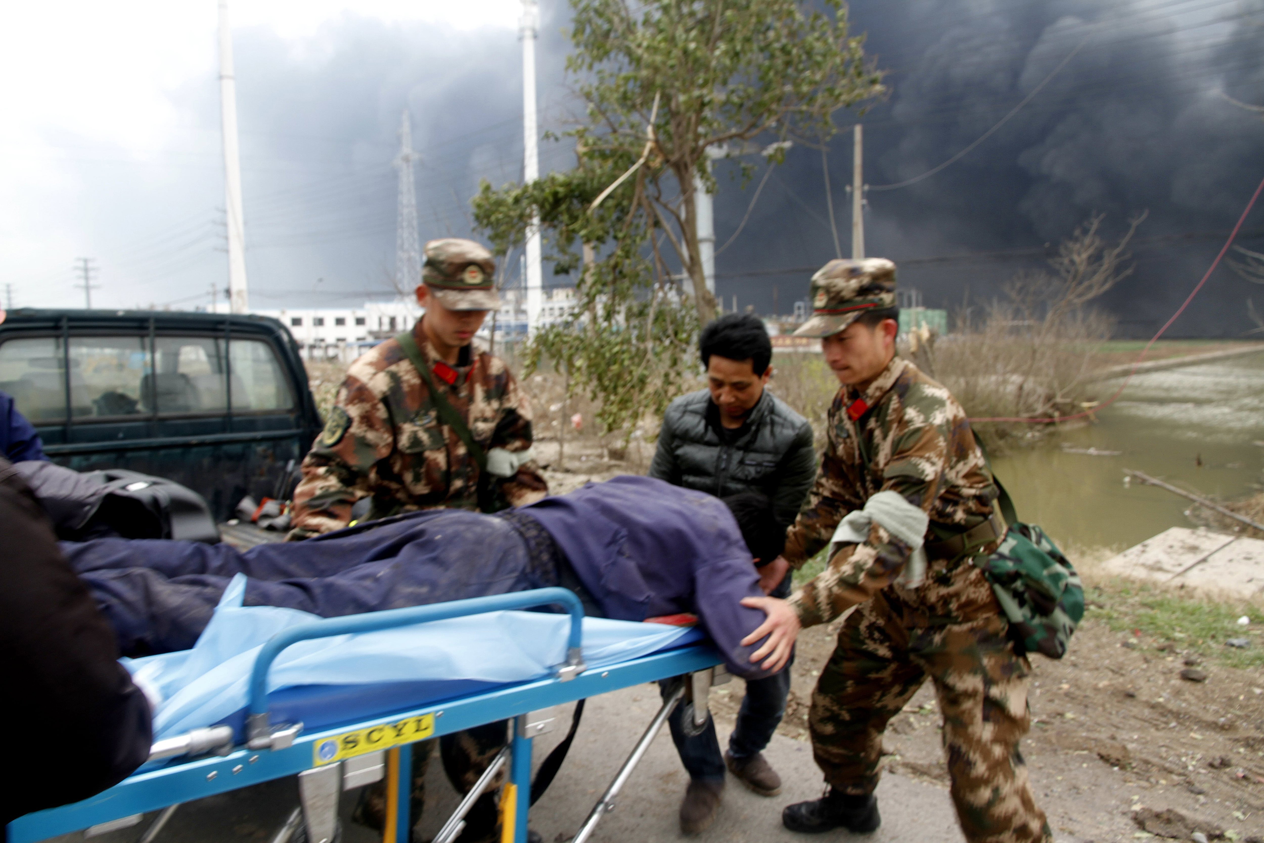 In this Thursday, March 21, 2019, photo, rescuers transport an injured person near the site of a factory explosion in a chemical industrial park in Xiangshui County of Yancheng in eastern China's Jiangsu province. The local government reports the death toll in an explosion at a chemical plant in eastern China has risen with dozens killed and more seriously injured.