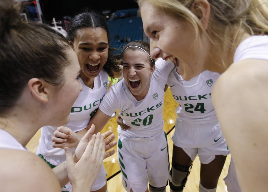 Oregon’s Satou Sabally, second from left, Sabrina Ionescu (20), Ruthy Hebard (24) and others celebrate after defeating UCLA in overtime in an NCAA college basketball game in the semifinals of the Pac-12 women’s tournament Saturday, March 9, 2019, in Las Vegas.