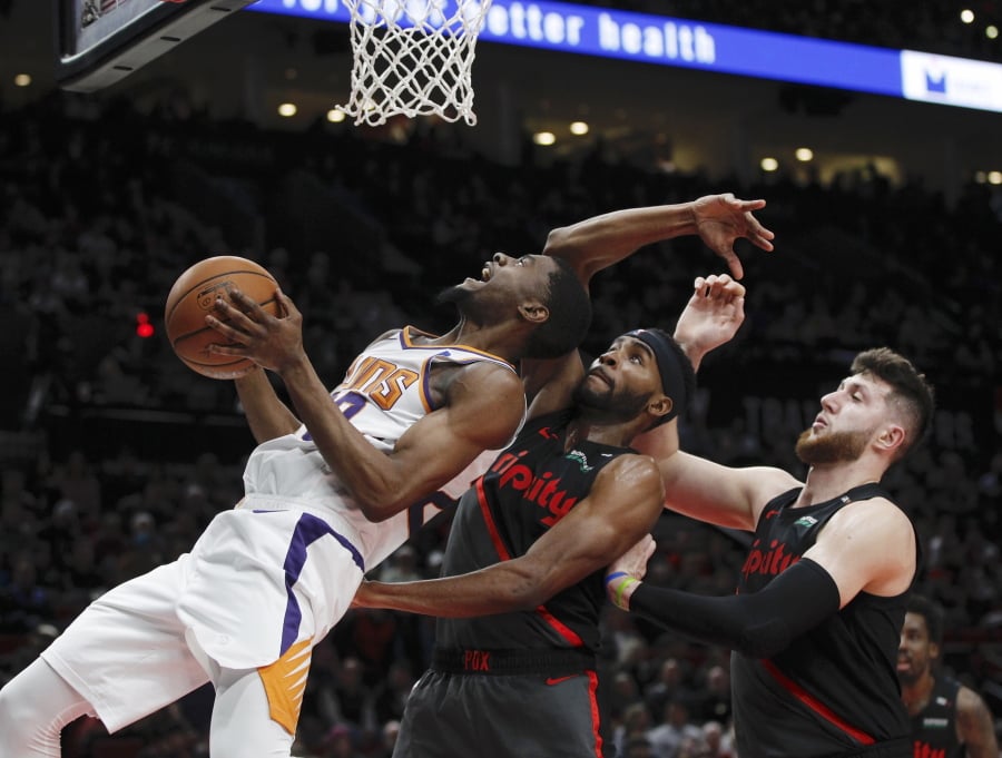 Suns forward Josh Jackson, left, prepares to shoot against the Blazers’ Maurice Harkless, center, and Jusuf Nurkic.
