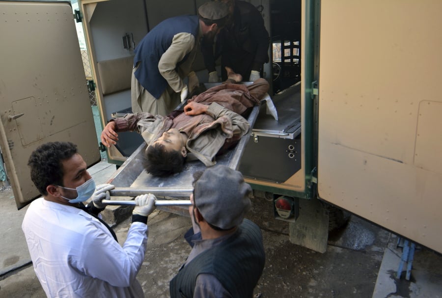 Afghans carry the body of a man who was killed in a suicide attack, at a hospital in Jalalabad province, east of Kabul, Afghanistan, Wednesday, March 6, 2019. An Afghan official said Wednesday that militants set off a suicide blast and stormed a construction company near the airport in Jalalabad, the capital of eastern Nangarhar province, killing at least 16 people.