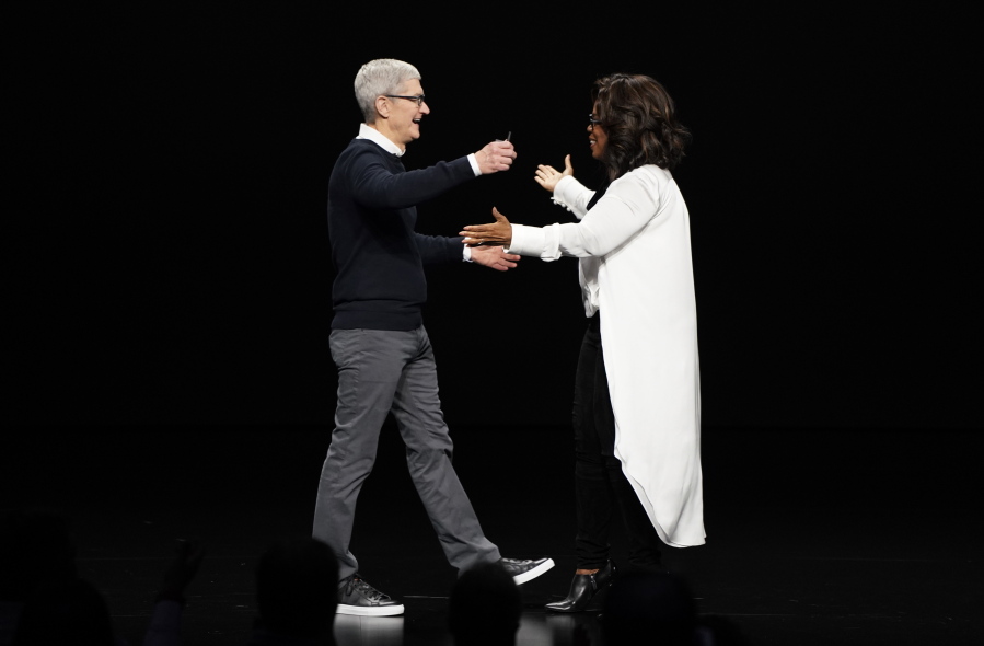 Apple CEO Tim Cook and Oprah Winfrey prepare to embrace at the Steve Jobs Theater during an event to announce new products Monday, March 25, 2019, in Cupertino, Calif.