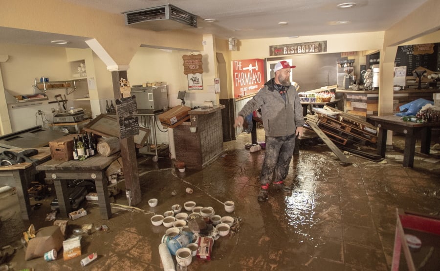 Farmhand Deli co-owner Jason Flint surveys the damage inside his restaurant Friday along River Road in Guerneville, Calif., as flood waters from the Russian River continue to recede.
