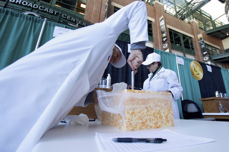 Judge Ben Novak attempts to obtain a piece of marbled curd cheese Tuesday, March 5, 2019 at the United States Championship Cheese Contest in Green Bay, Wis. The three-day event includes more cheese, butter and yogurt makers than ever before. It’s is considered the largest technical cheese, butter and yogurt competition in the country.