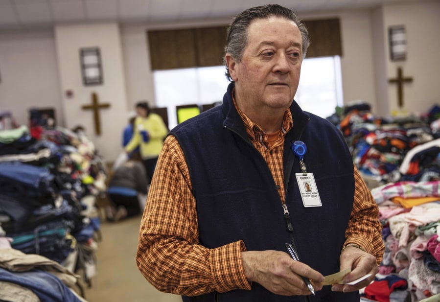In this Wednesday, March 6, 2019 photo, Rusty Sowell, pastor at Providence Baptist Church, speaks to volunteers organizing donations at the church in Beauregard, Ala. Dealing with the dead became a huge task in a rural Alabama community where nearly two dozen people died in a tornado outbreak. The county coroner, Bill Harris, set up a temporary command post and performed post-mortem exams. He and Sowell then held 17 separate meetings with relatives of the 23 people who died.