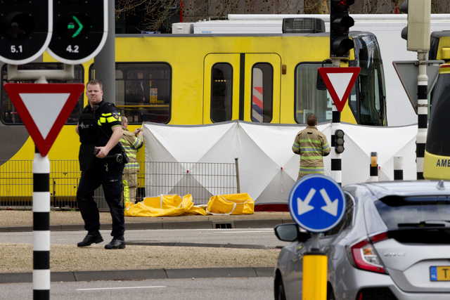Rescue workers install a screen on the spot where a body was covered with a white blanket following a shooting in Utrecht, Netherlands, Monday, March 18, 2019. Police in the central Dutch city of Utrecht say on Twitter that "multiple" people have been injured as a result of a shooting in a tram in a residential neighborhood.