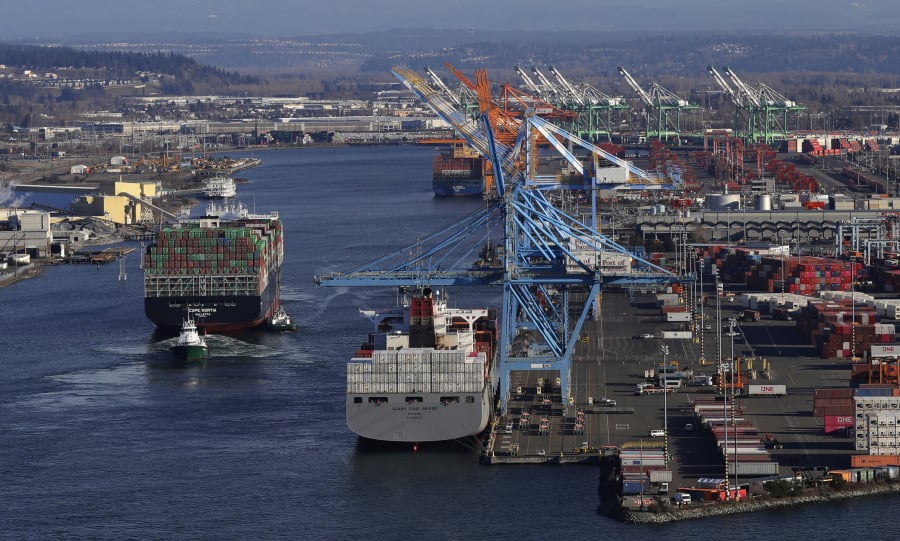 The Cape Kortia container ship, left, heads into the Port of Tacoma in Commencement Bay on March 5 in Tacoma. Ted S.