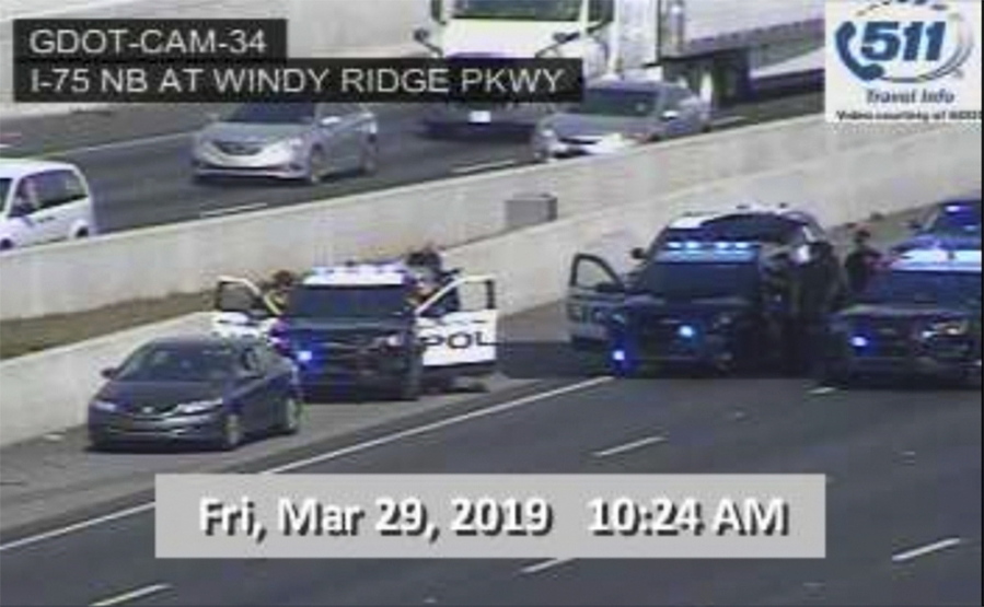 In this image made from video provided by the Georgia Department of Transportation, Marietta Police block southbound lanes on Interstate-75, near Marietta, Ga., North of Atlanta, Friday, March 29, 2019. Marietta police said in a brief statement that the southbound lanes of Interstate 75 were shut down Friday morning due to a motorist stopped on the freeway just northwest of Atlanta.