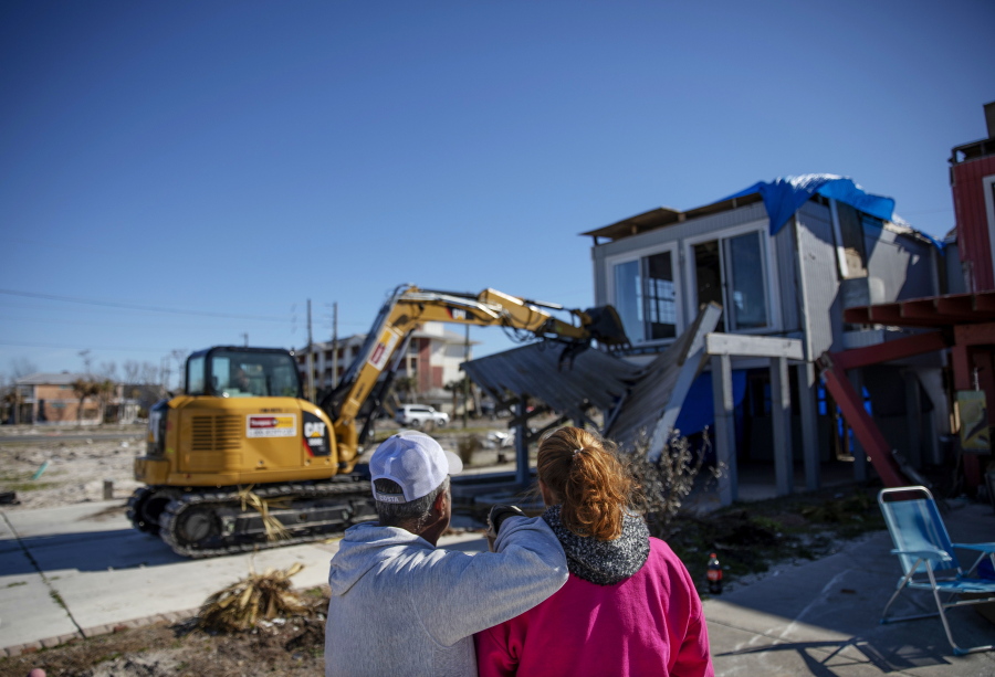 Jaques, left, and his wife, Paulina “Bela” Sebastiao, watch as their home, damaged in Hurricane Michael, is torn down Jan. 25 in Mexico Beach, Fla.
