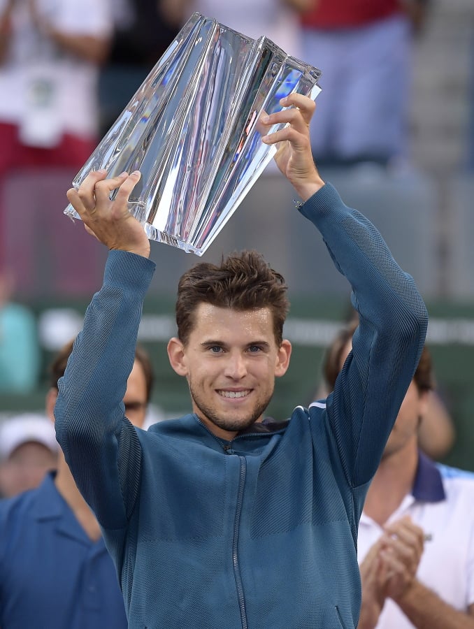 Dominic Thiem, of Austria, raises a trophy over his head after defeating Roger Federer, of Switzerland, in the men’s final at the BNP Paribas Open tennis tournament Sunday, March 17, 2019, in Indian Wells, Calif. Thiem won 3-6, 6-3, 7-5. (AP Photo/Mark J.