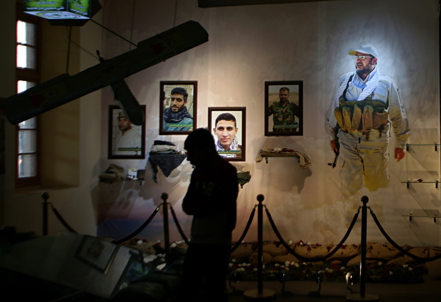 In this Friday, Feb. 1, 2019 photo, pictures of militiamen who died fighting the Islamic State group over the past four years and weapons are on display in the Popular Mobilization Forces War Museum on al-Mutanabi Street, Baghdad, Iraq. The museum is meant to honor the fallen but it also underscores the Iran-backed Shiite militias’ growing clout in the country. Their political and military might soared after they helped the government defeat IS and they’re now accused of building a parallel state within Iraq.