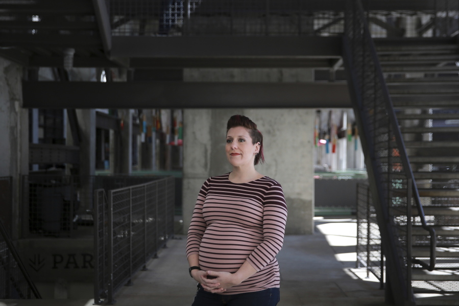 In this March. 6, 2019, photo Valarie Regas poses for a photo at Ponce City Market in Atlanta. Child care costs delayed Regas’ return to the job market after she gave birth to her second child in 2012. Regas wanted to go back, but most of the jobs she found didn’t pay enough to cover child care. So, she remained mostly out of the job market for five more years. After completing a coding boot camp, Regas was hired last year by a division of the European aerospace giant Airbus.