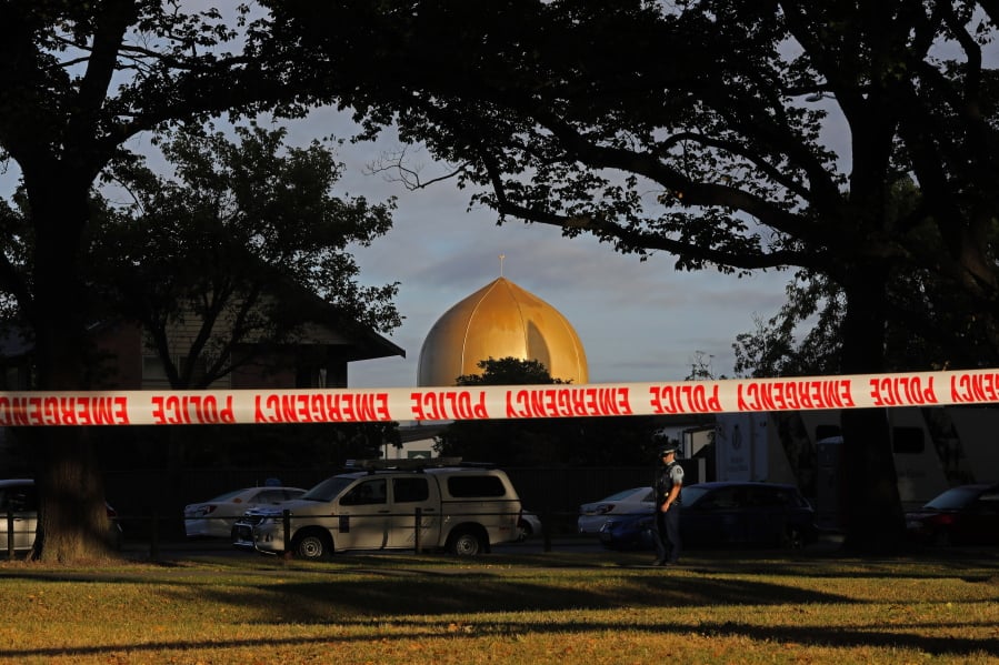 FILE - In this March 17, 2019, file photo, a police officer stands guard in front of the Masjid Al Noor mosque in Christchurch, New Zealand, where one of two mass shootings occurred. Growing certainty that a single gunman was responsible for the attacks renews attention to warnings about the threat of terror attacks by ideologically driven lone actors. But stereotypes of such attackers, often called “lone wolves” in the U.S., risks obscuring the fact that many are not as solitary as some might believe, criminologists say.