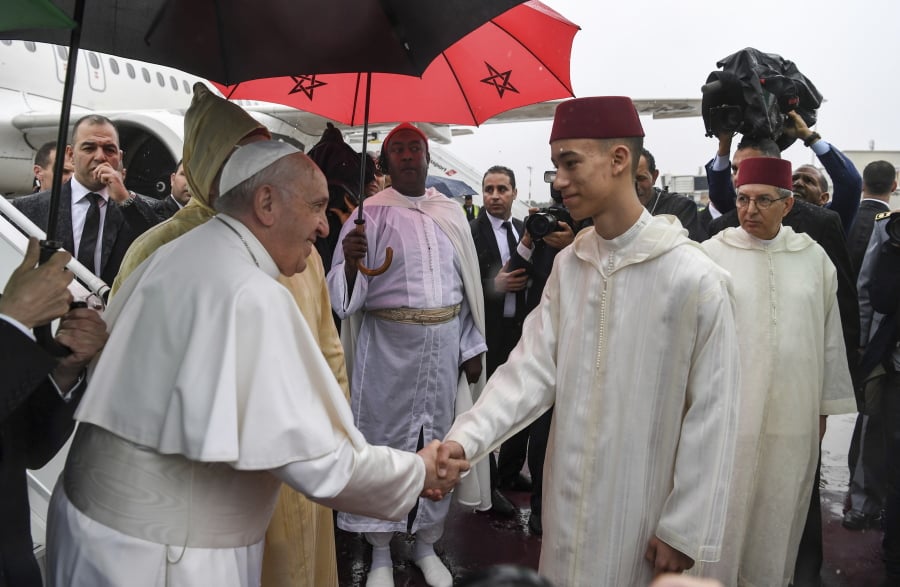 Pope Francis is greeted by Morocco’s Crown Prince Moulay Moulay Hassan on Saturday after disembarking from his plane at Rabat-Sale International Airport.