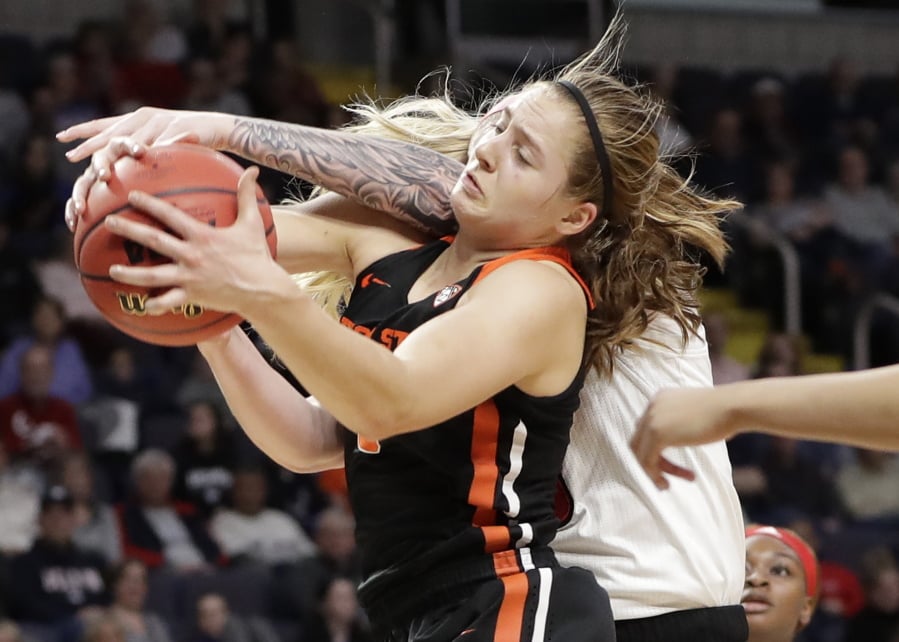 Oregon State guard Mikayla Pivec (0) battles for the ball with Louisville forward Sam Fuehring during the first half of a regional semifinal game in the NCAA women’s college basketball tournament, Friday, March 29, 2019, in Albany, N.Y.