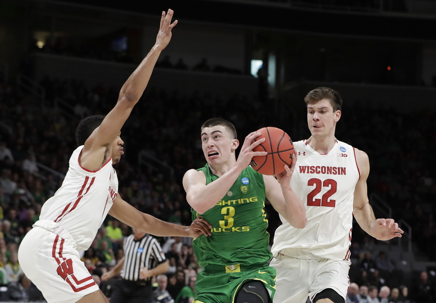 Oregon guard Payton Pritchard (3) drives between Wisconsin guard D’Mitrik Trice, left, and forward Ethan Happ (22) during the first half of a first-round game in the NCAA men’Äôs college basketball tournament Friday, March 22, 2019, in San Jose, Calif.