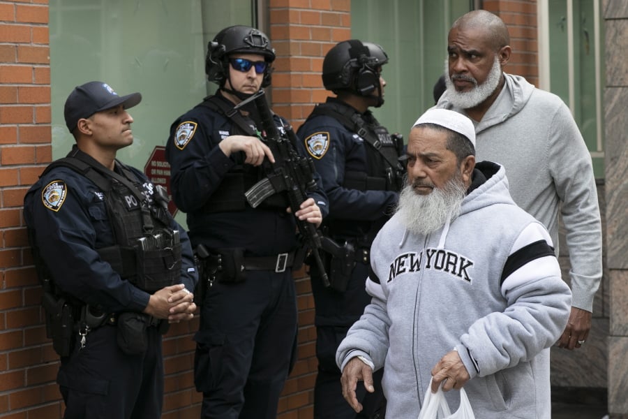 Men leave the Islamic Cultural Center of New York under increased police security following the shooting in New Zealand, Friday in New York.
