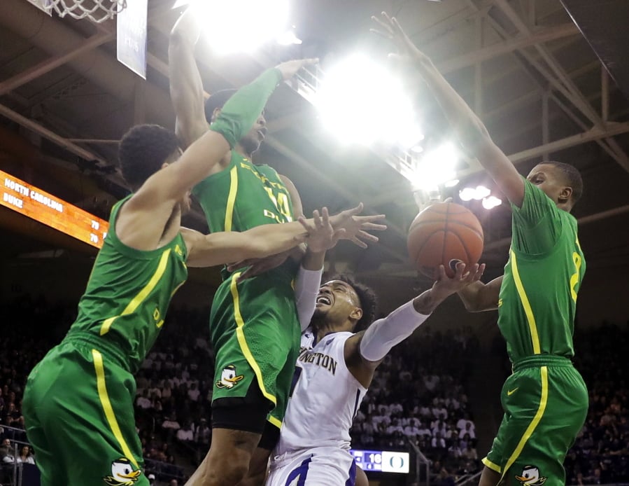 Washington guard David Crisp, second from right, is blocked by Oregon forward Kenny Wooten, second from left, Will Richardson, left, and Louis King, right, during the first half of an NCAA college basketball game, Saturday, March 9, 2019, in Seattle. (AP Photo/Ted S.