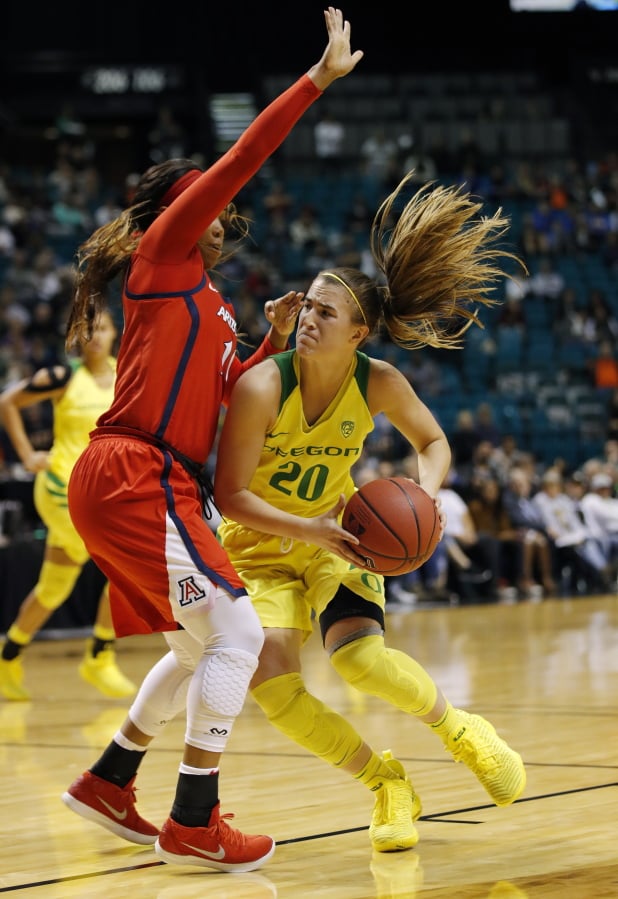 Oregon’s Sabrina Ionescu, right, drives around Arizona’s Tee Tee Starks during the second half of an NCAA college basketball game at the Pac-12 women’s tournament Friday, March 8, 2019, in Las Vegas.