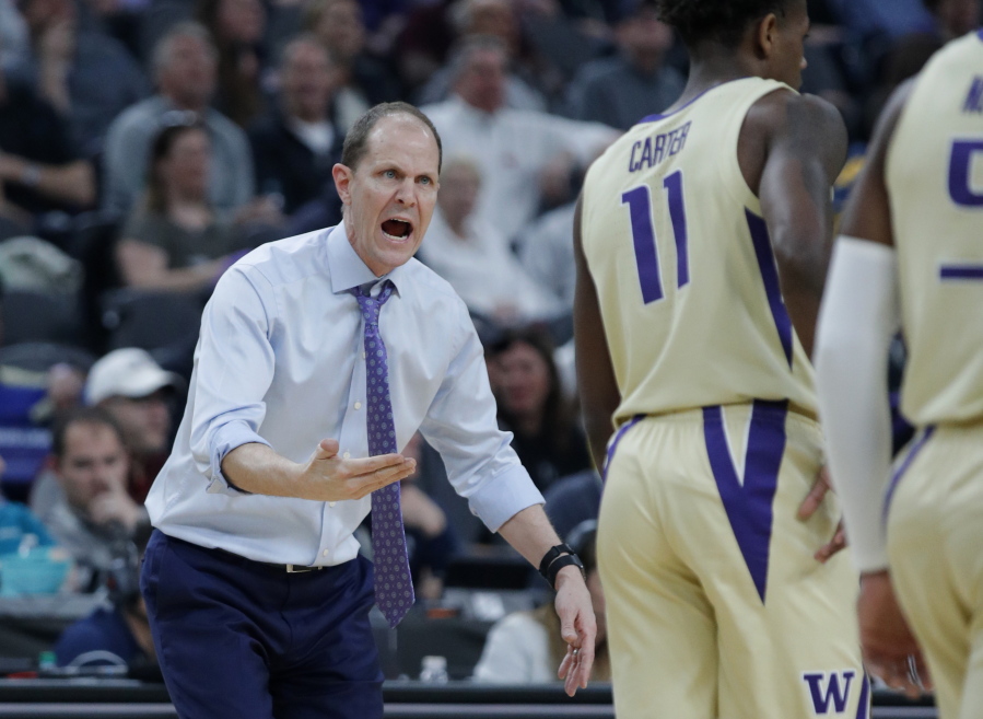 Washington head coach Mike Hopkins speaks with his players during the first half of an NCAA college basketball game against Colorado in the semifinals of the Pac-12 men’s tournament Friday, March 15, 2019, in Las Vegas.
