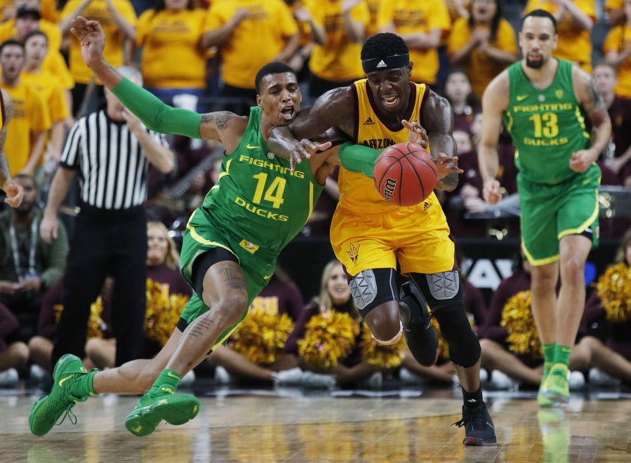 Oregon’s Kenny Wooten (14) tries to steal the ball from Arizona State’s Zylan Cheatham during the first half of an NCAA college basketball game in the semifinals of the Pac-12 men’s tournament Friday, March 15, 2019, in Las Vegas.