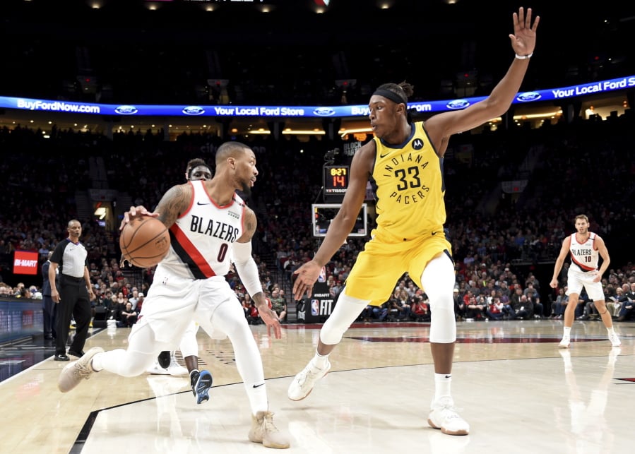 Portland Trail Blazers guard Damian Lillard, left, tries to get past, Indiana Pacers center Myles Turner, right, during the first half of an NBA basketball game in Portland, Ore., Monday March 18, 2019.