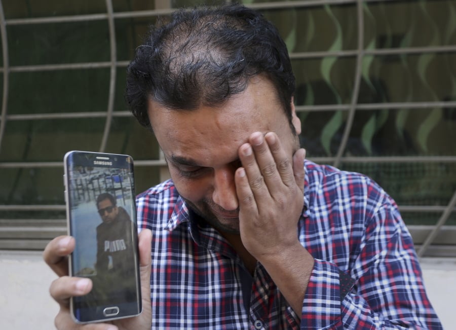 A relative weeps while showing the picture of Sohail Shahid, a Pakistani citizen who was killed in Christchurch mosque shootings, on his cell phone outside his home in Lahore, Pakistan, Sunday, March 17, 2019. Pakistan’s foreign ministry spokesman says three more Pakistanis have been identified among the dead increasing the number of Pakistanis to nine killed in the mass shootings at two mosques in the New Zealand city of Christchurch. (AP Photo/K.M.