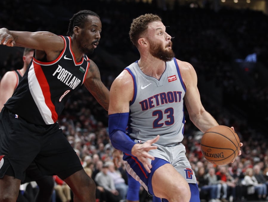 Detroit Pistons forward Blake Griffin, right, spins to the basket next to Portland Trail Blazers forward Al-Farouq Aminu during the first half of an NBA basketball game in Portland, Ore., Saturday, March 23, 2019.