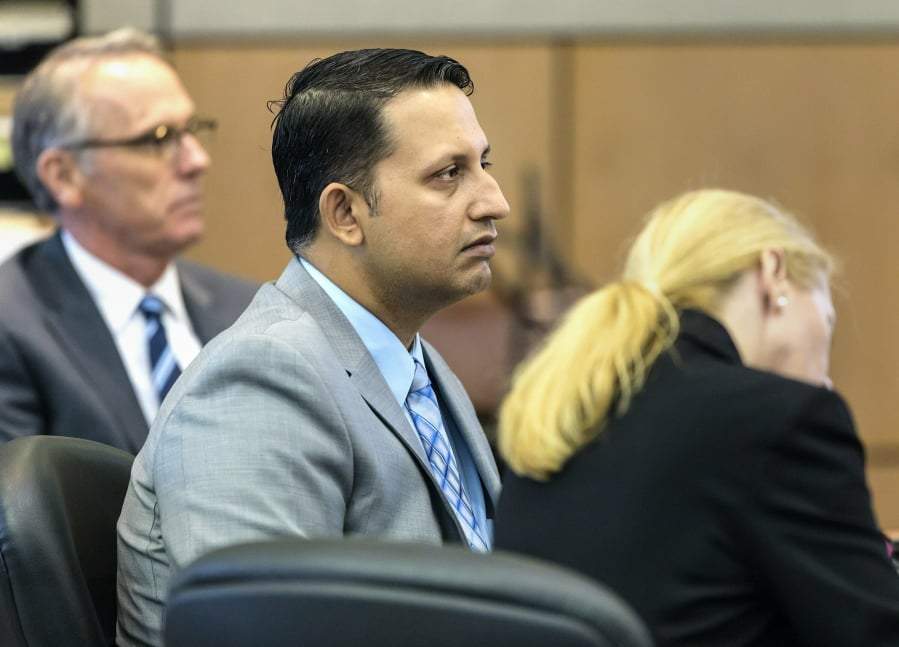 Nouman Raja sits between defense attorney Scott Richardson, left, and paralegal Debi Stratton as attorney Richard Lubin gives his closing arguments in Raja’s trial, Wednesday, March 6, 2019 in West Palm Beach, Fla. Raja, a former Palm Beach Gardens police officer, is charged with the fatal 2015 shooting of stranded motorist Corey Jones.