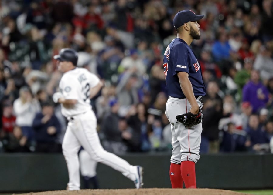 Boston Red Sox starting pitcher Eduardo Rodriguez, right, looks away as Seattle Mariners’ Jay Bruce rounds the bases behind on his three-run home run in the fifth inning of a baseball game Saturday, March 30, 2019, in Seattle.