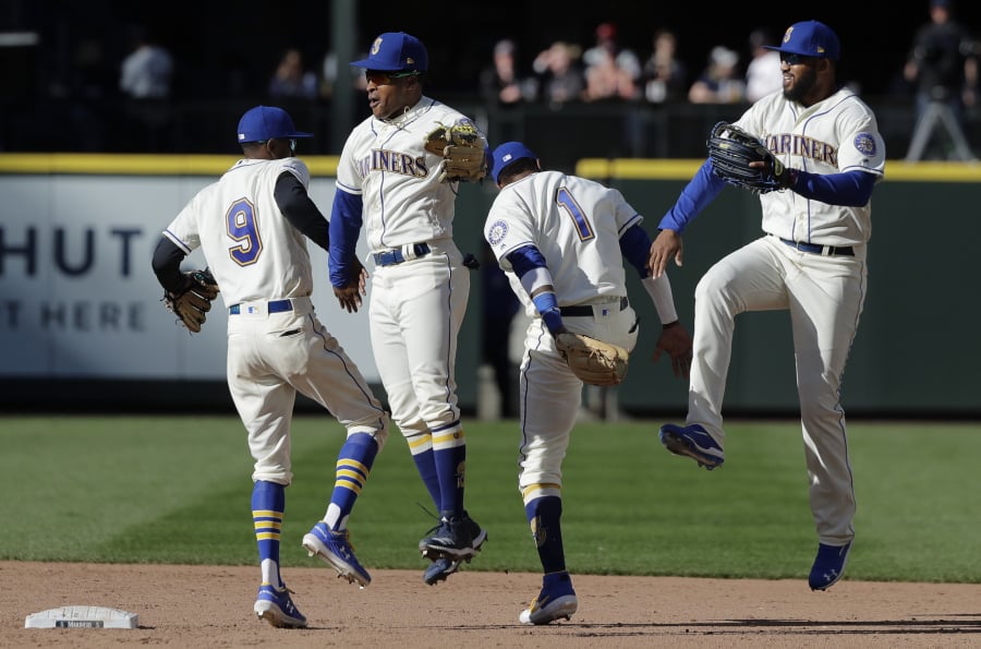 Seattle Mariners’ (from left) Dee Gordon, Mallex Smith, Tim Beckham, and Domingo Santana celebrate at the end of a baseball game against the Boston Red Sox, Sunday, March 31, 2019, in Seattle. The Mariners won 10-8. (AP Photo/Ted S.