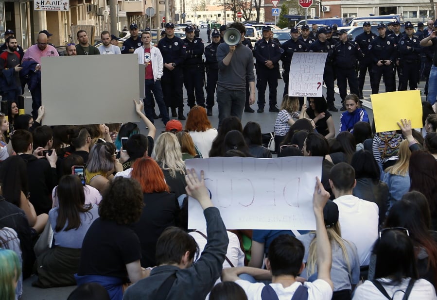 High-school students protest in front of main police station in Belgrade, Serbia, Monday, March 18, 2019. Dozens of high-school students have staged a sit-down protest demanding that the authorities release from detention a fellow-student who was jailed during weekend anti-government protests in Serbia.