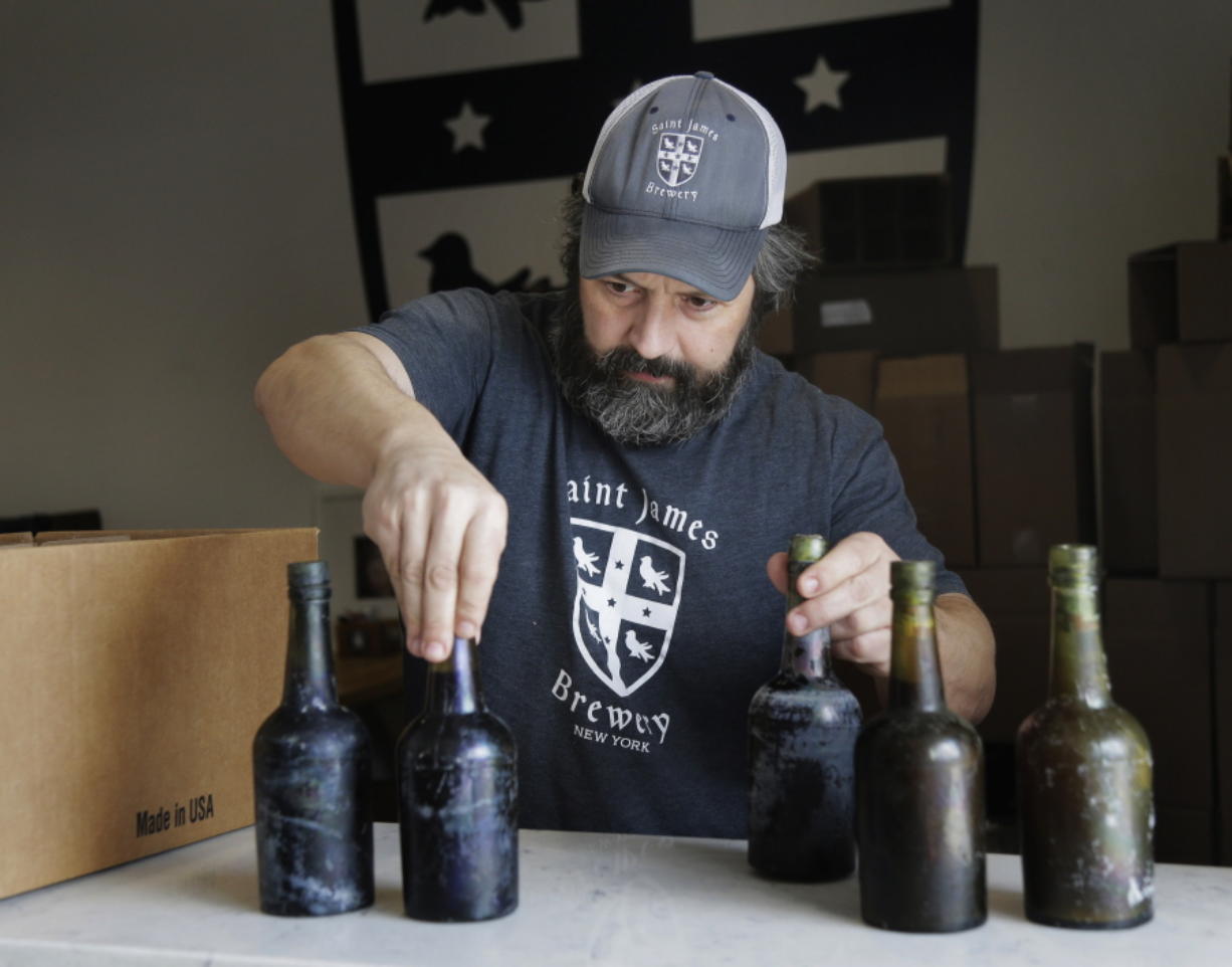 In this March 4, 2019, photo, Jamie Adams shows some intact beer bottles recovered from the shipwreck of the SS Oregon at his St. James Brewery in Holbrook, N.Y. Adams created an ale called Deep Ascent using the yeast from the bottles recovered from the Liverpool-to-New York luxury liner that sank off Fire Island in 1886.