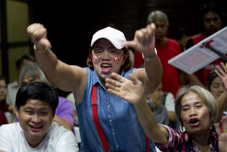 Frustrated supporters of the Pheu Thai party cheer as election results are broadcast on a television in Bangkok on Sunday. Figures from Thailand’s Election Commission show a military-backed party has taken the lead in the country’s first election since a 2014 coup.