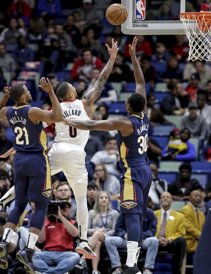 Portland Trail Blazers guard Damian Lillard (0) shoots over New Orleans Pelicans center Julius Randle (30) and forward Darius Miller (21) in the first half of an NBA basketball game in New Orleans, Friday, March 15, 2019.